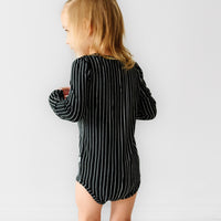 Back view image of a child wearing a Jack Skellington graphic bodysuit