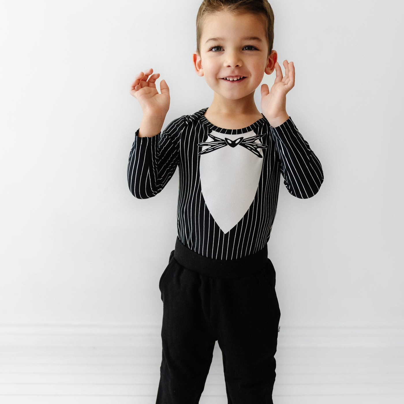 Close up image of a child wearing a Jack Skellington graphic bodysuit and coordinating black joggers