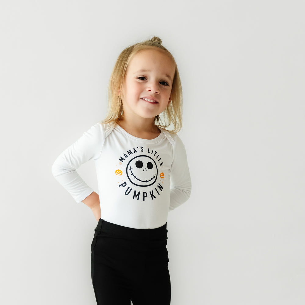 Child wearing a Mama's Little Pumpkin graphic bodysuit and black leggings