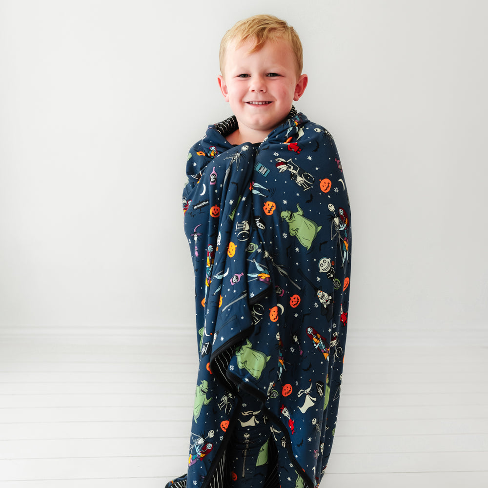 Child wrapped up in a Jack Skellington and Friends printed large cloud blanket