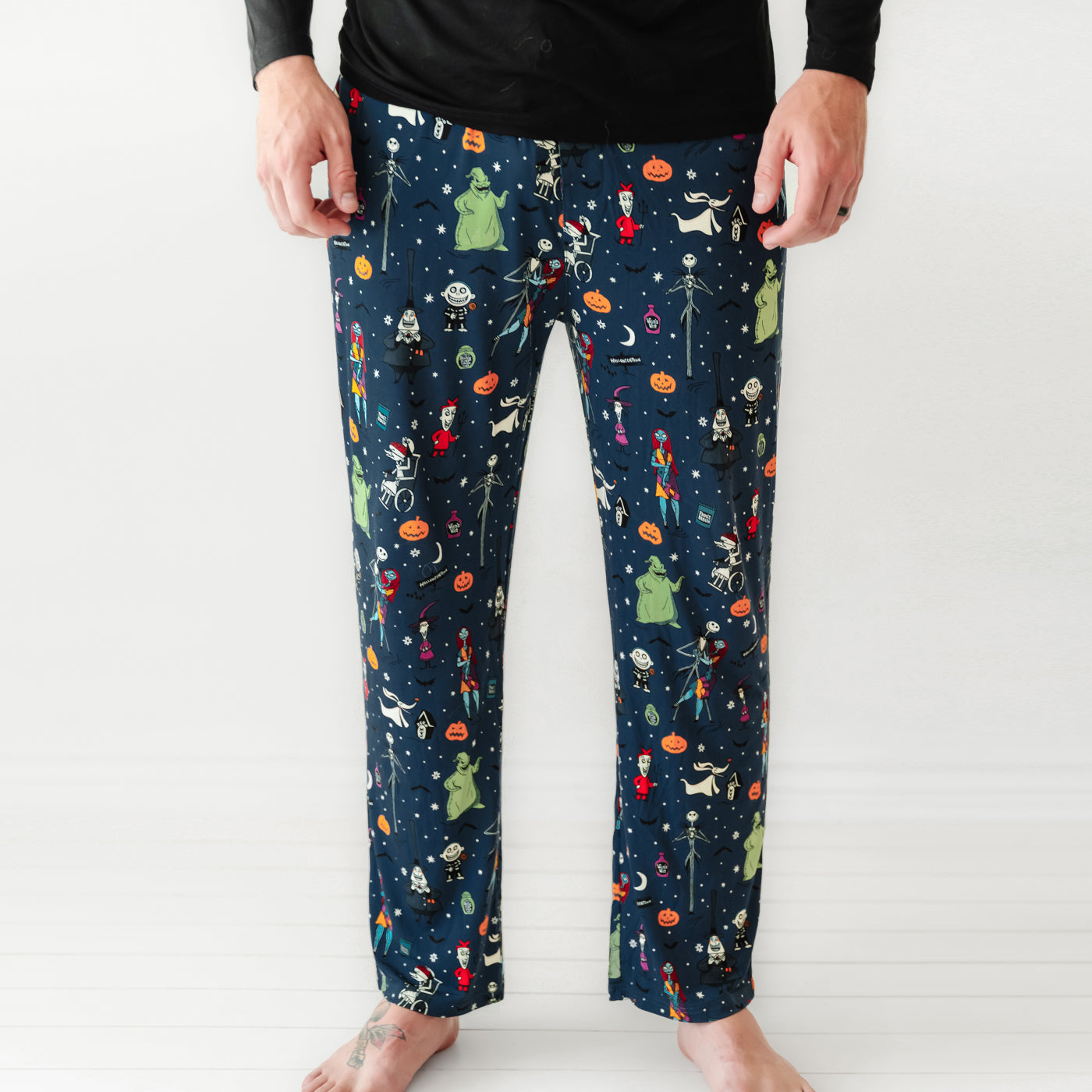 Close up image of a man wearing Jack Skellington and Friends printed men's pajama pants