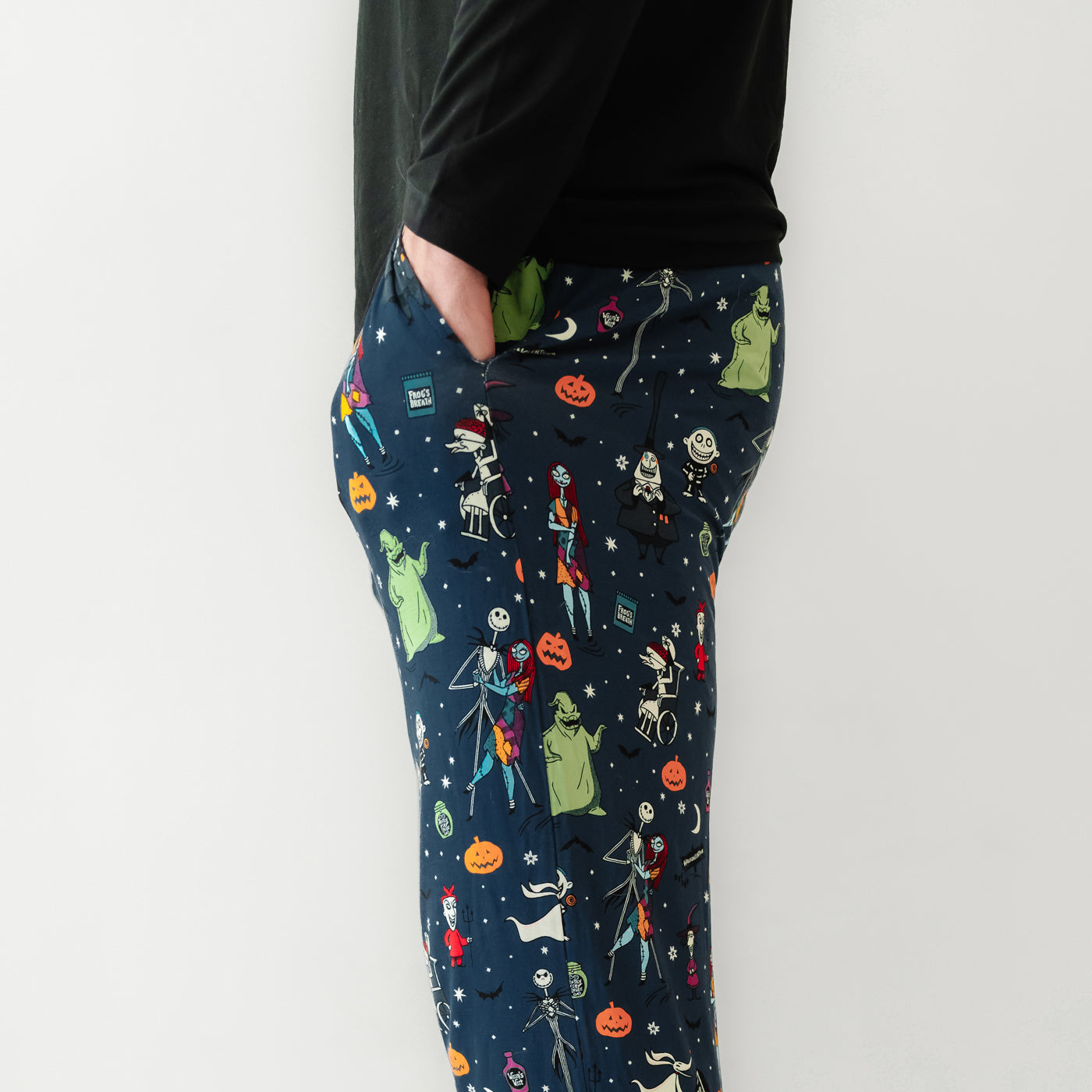 Side view image of a man wearing Jack Skellington and Friends printed men's pajama pants