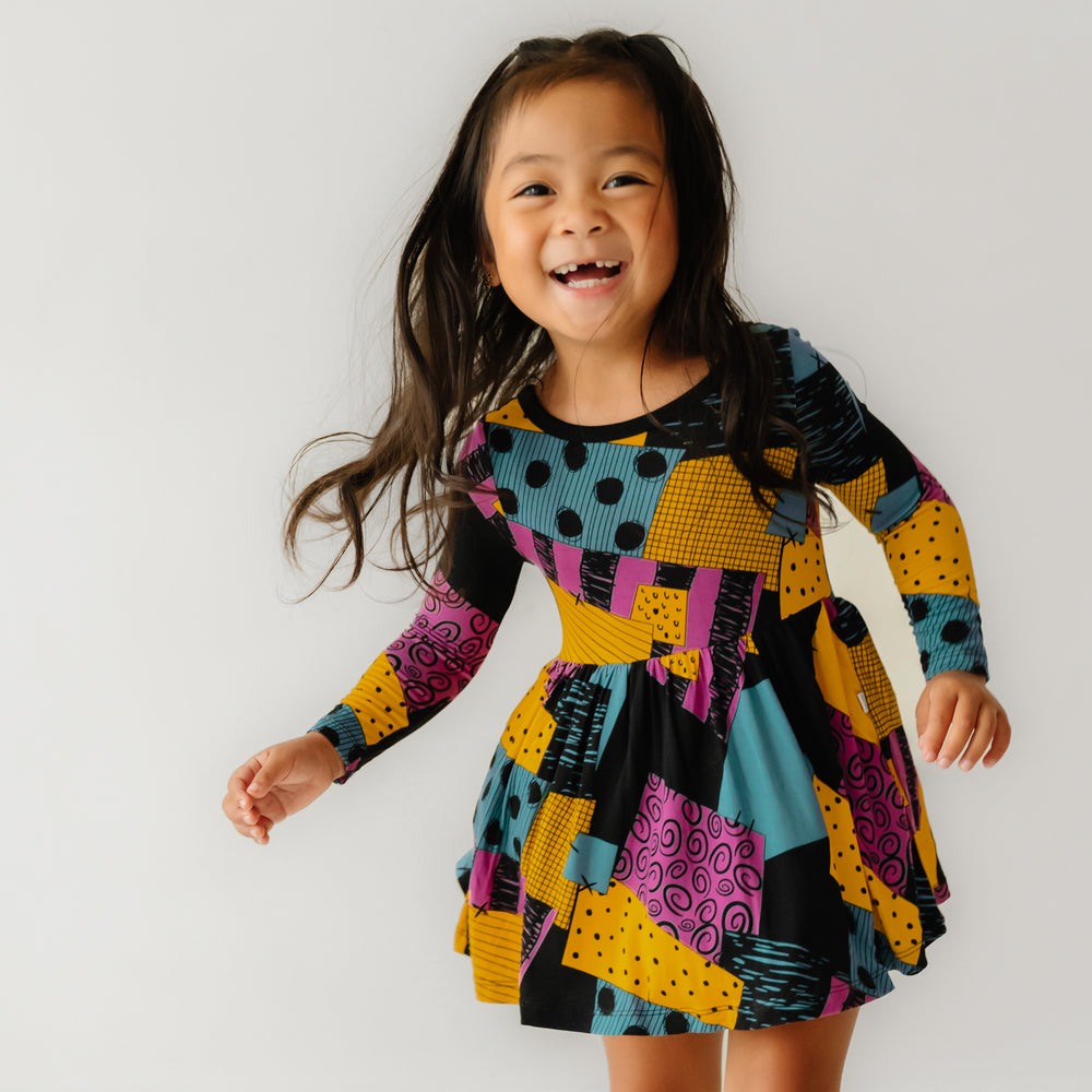 Child jumping wearing a Sally's Patchwork twirl dress with bodysuit