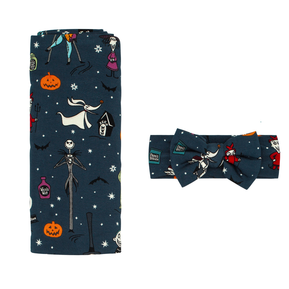 Flat lay image of a Jack Skellington and Friends printed swaddle and luxe bow headband set
