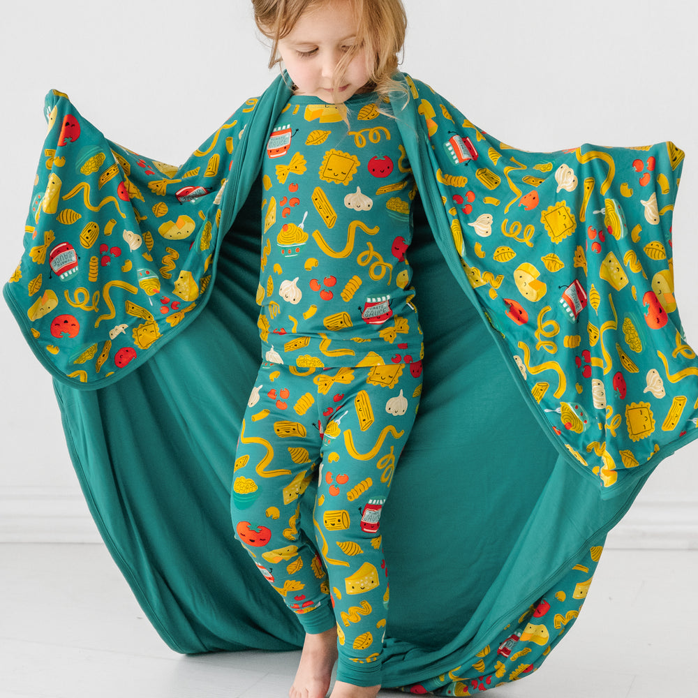 Click to see full screen - Child with a Pasta Party large cloud blanket draped over their shoulders and wearing matching pajamas