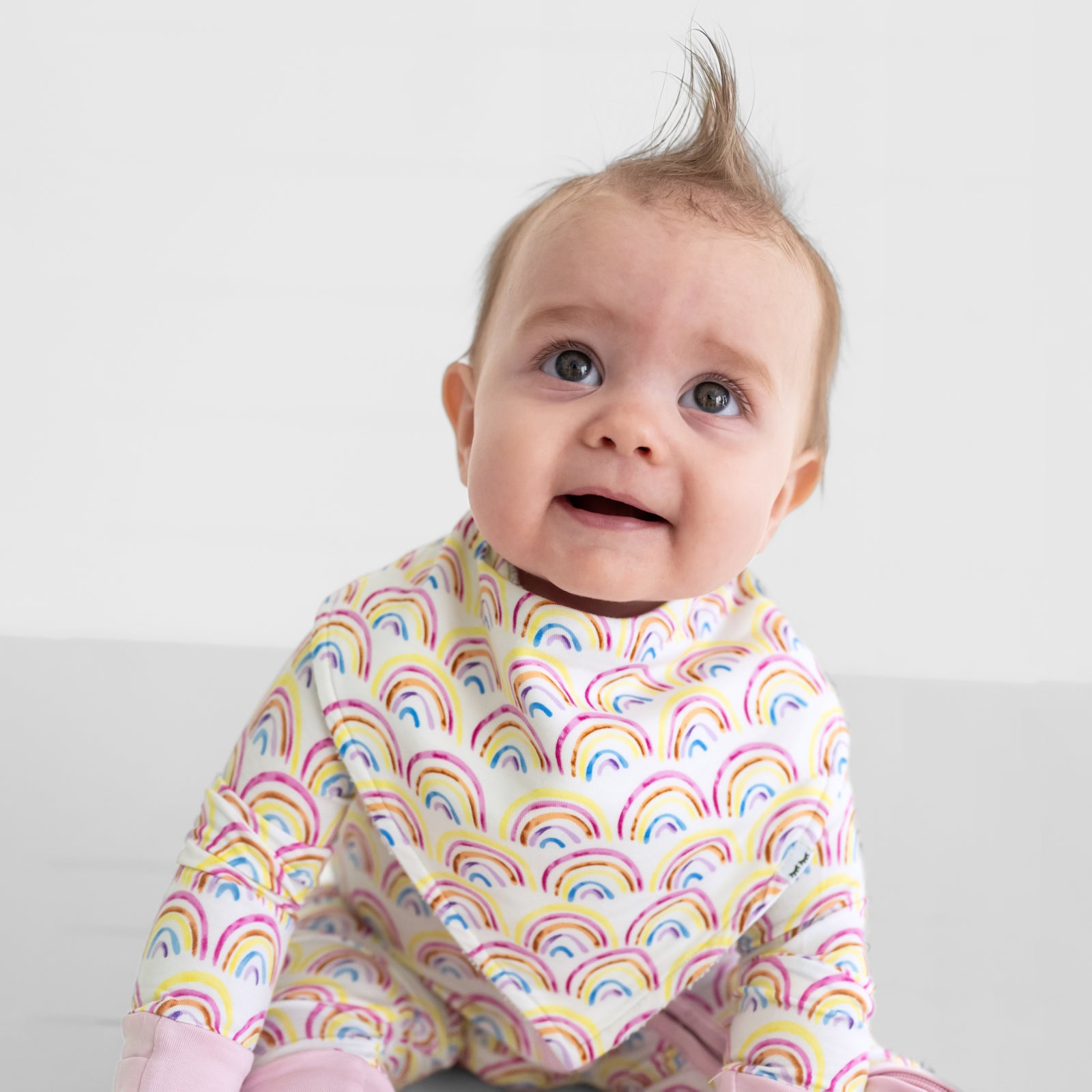 Close up of a child wearing a Pastel Rainbows baby bandana bib