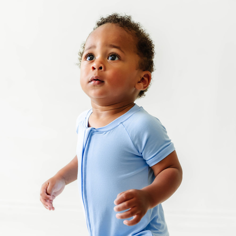 Close up image of a child wearing a Periwinkle Blue shorty romper 