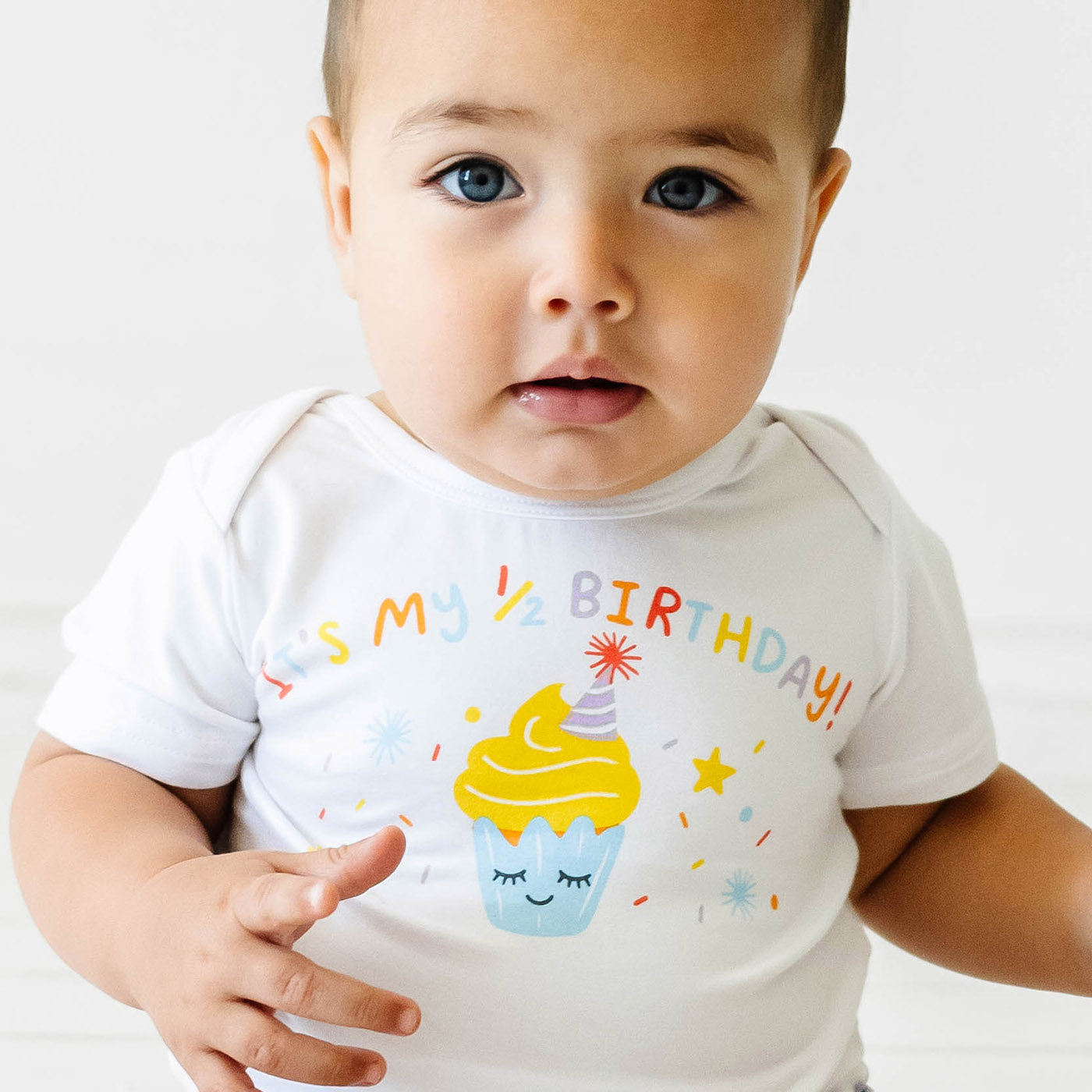 very close up image of a child wearing a It's my Half Birthday graphic bodysuit