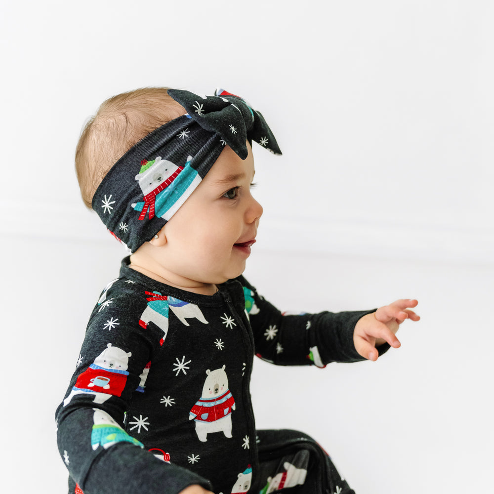 Click to see full screen - Alternate profile view of a child wearing a Polar Bear Pals luxe bow headband paired with a matching zippy