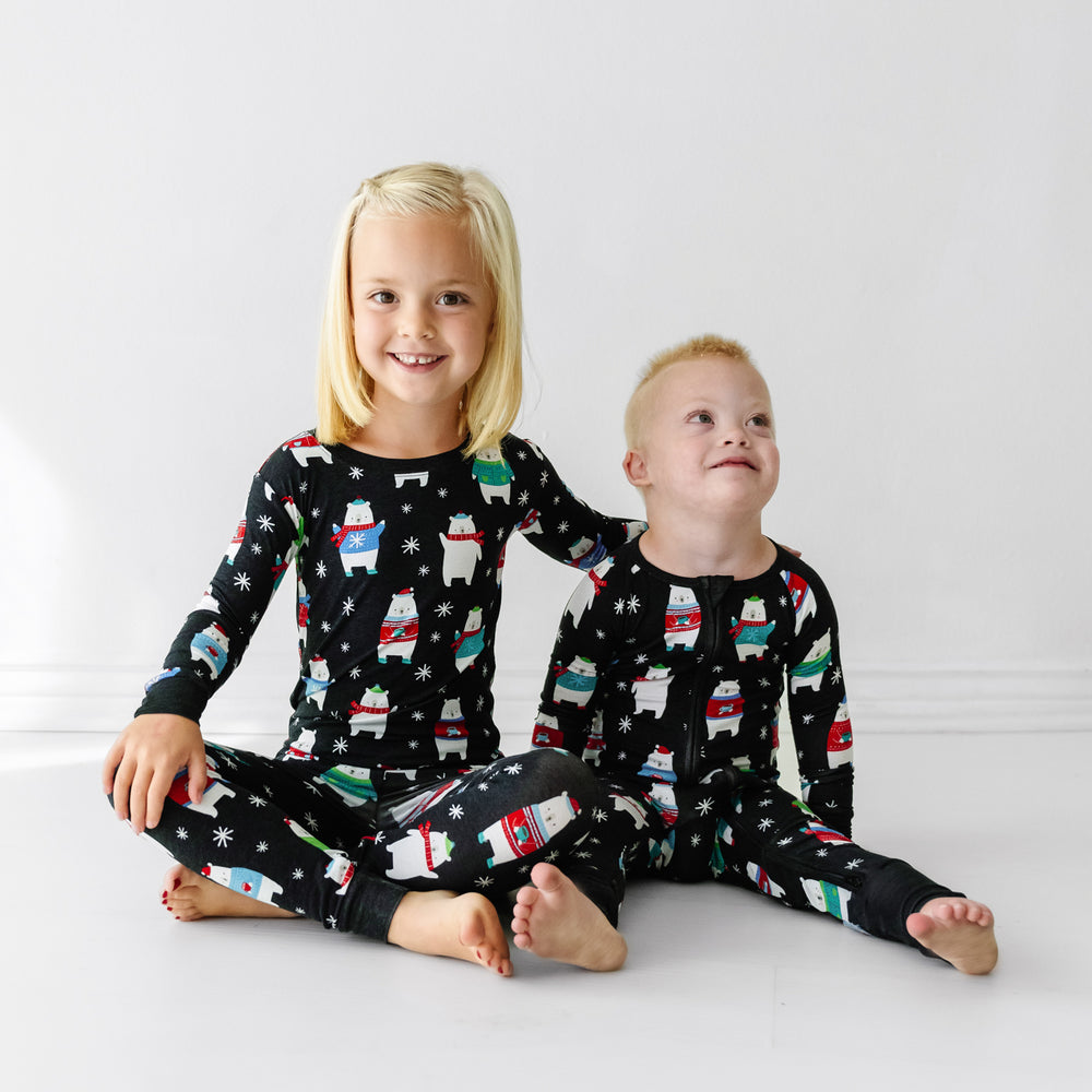 Click to see full screen - Two siblings wearing matching Polar Bear Pals pajamas in two piece and zippy styles