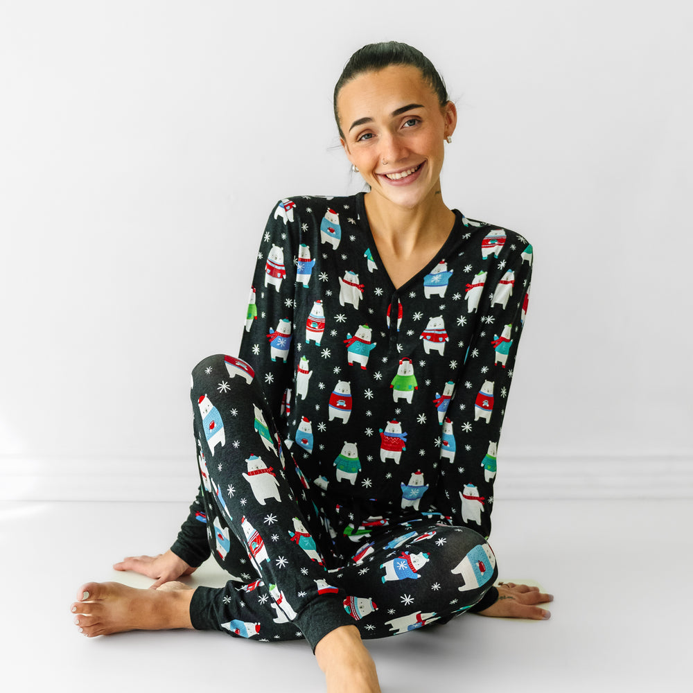 Woman sitting wearing matching Polar Bear Pals printed women's pajama top paired with women's pajama pants