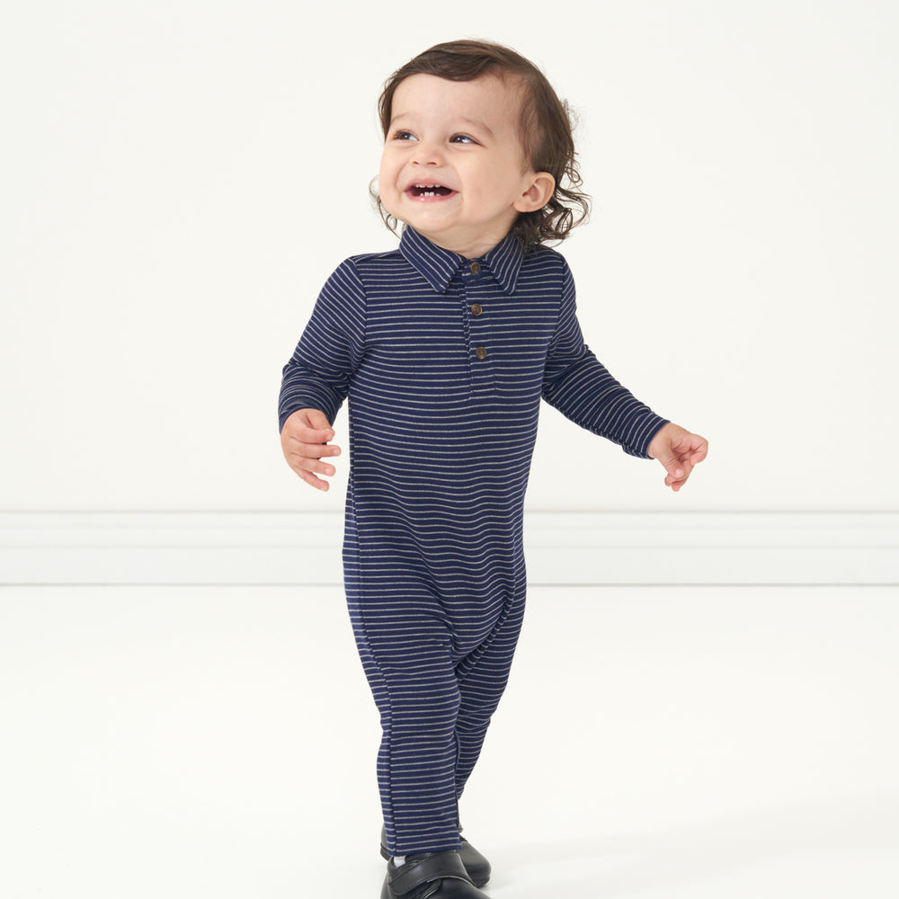 Child looking to the side wearing a Classic Navy Stripes polo romper