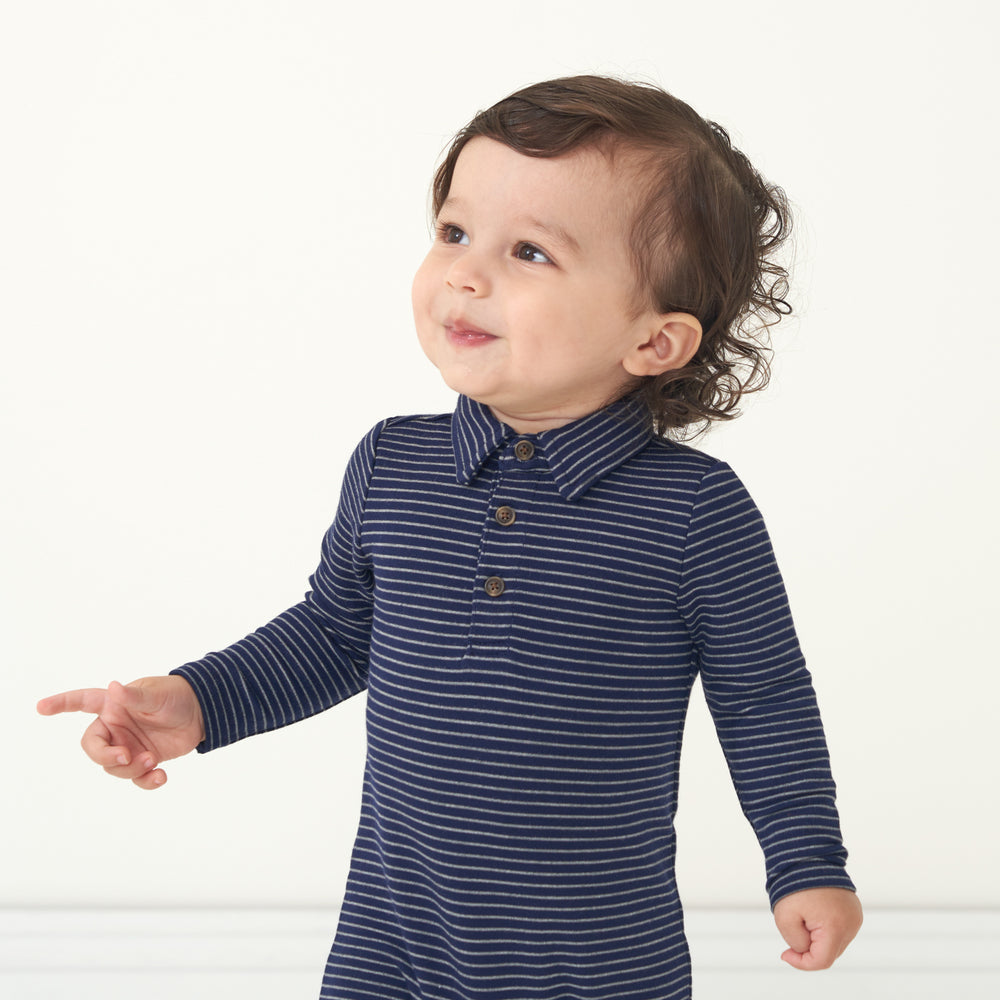 Close up image of a child wearing a Classic Navy Stripes polo romper