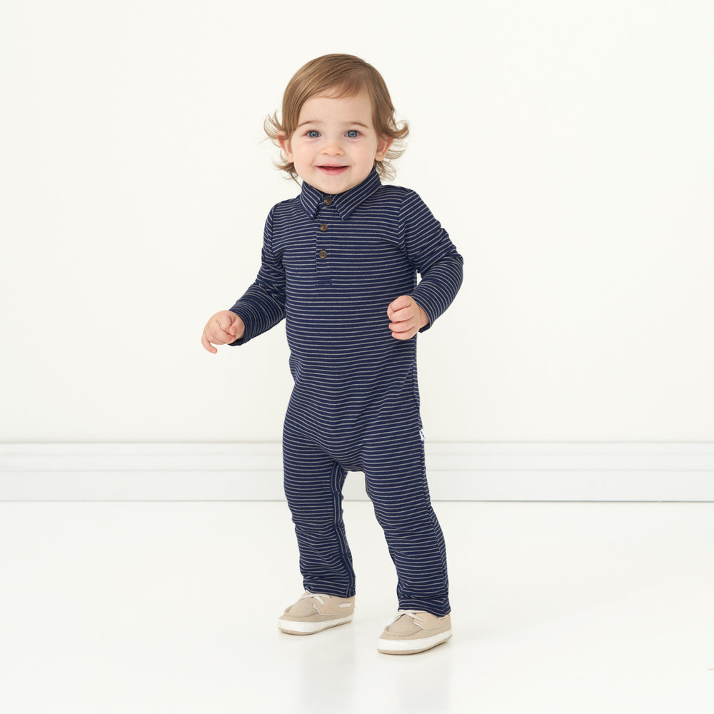 Child laughing wearing a Classic Navy Stripes polo romper