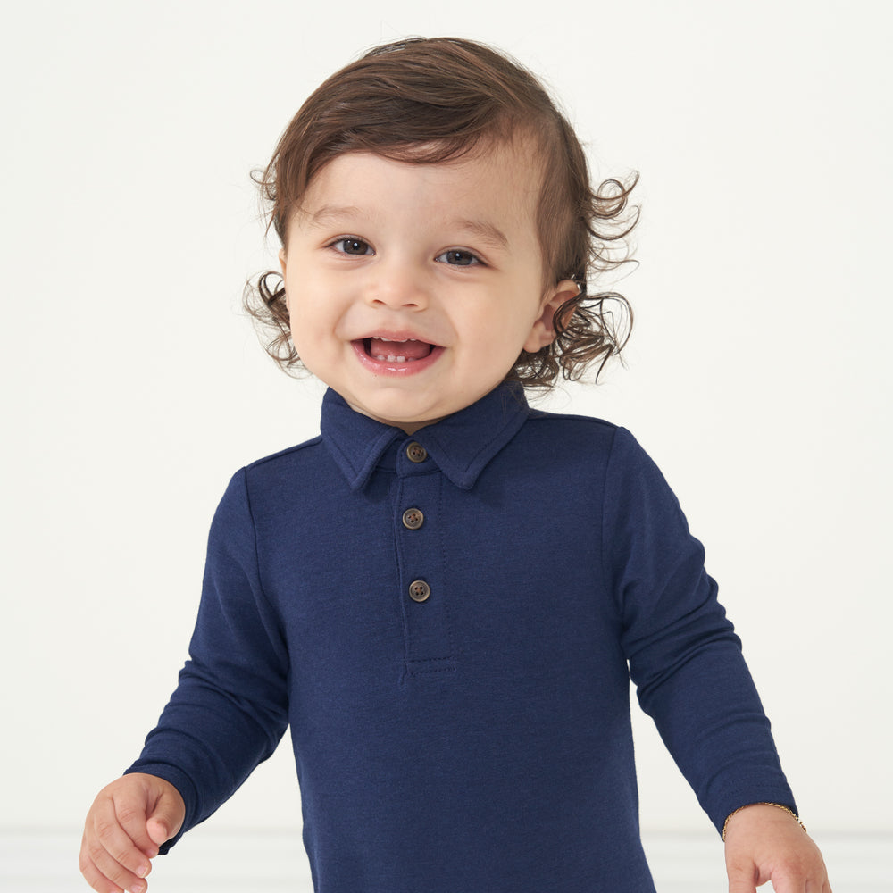 Close up image of a child wearing a Classic Navy polo romper