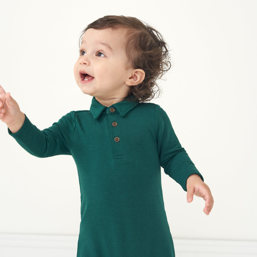 Close up image of a child wearing an Emerald polo romper