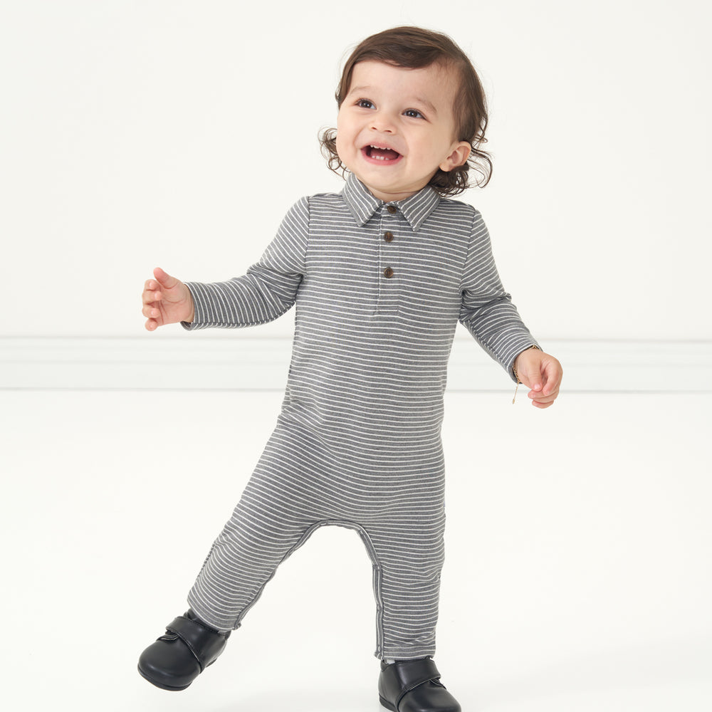 Child posing wearing a Heather Charcoal Stripes polo romper