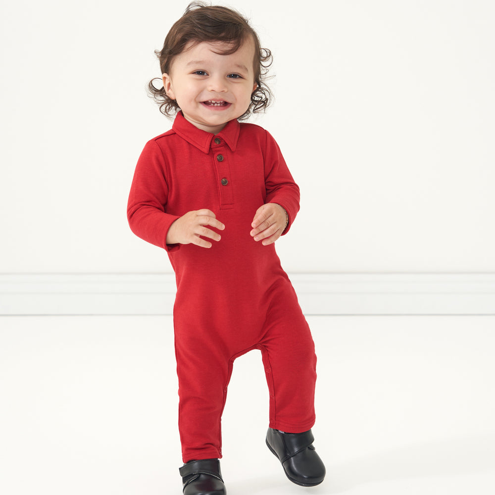 Child posing wearing a Holiday Red polo romper