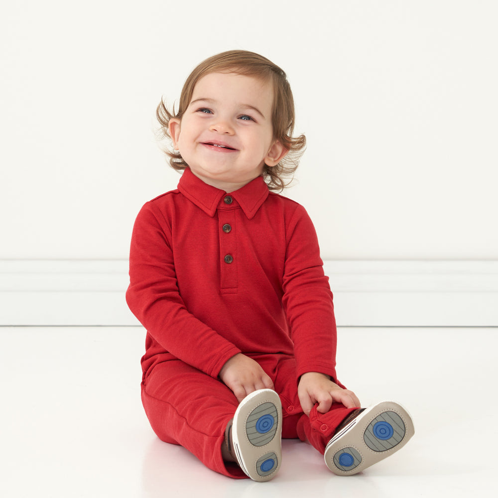 Child sitting wearing a Holiday Red polo romper