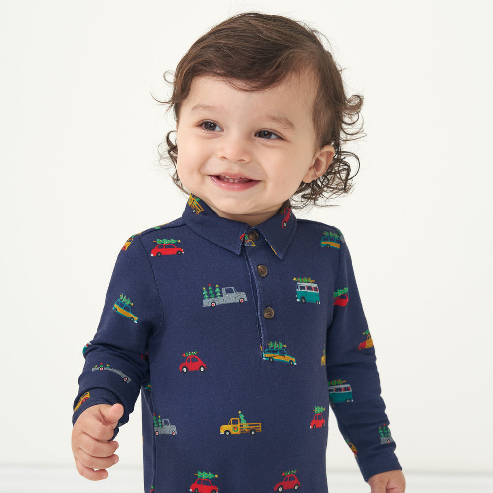 Close up image of a child wearing a Tree Traffic polo romper