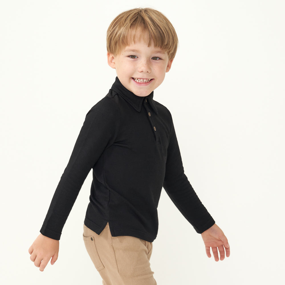 Side view image of a child wearing a Black polo shirt