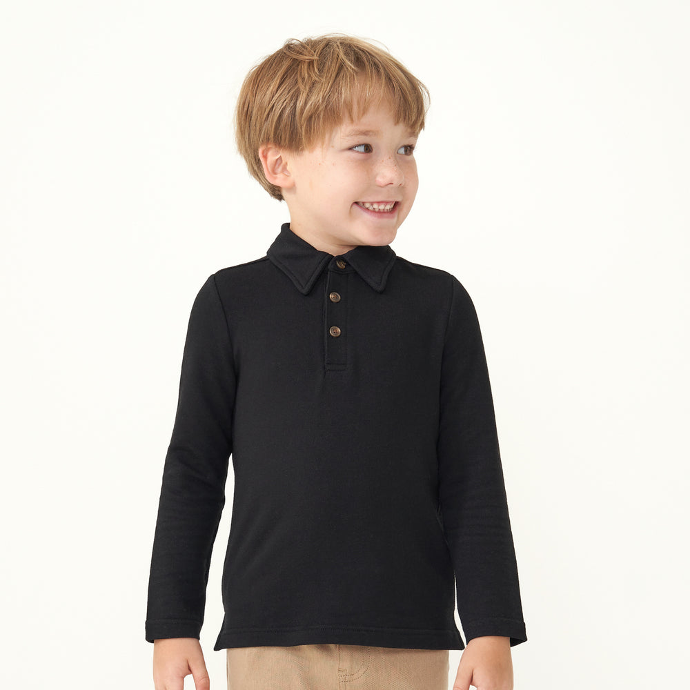 Child looking to the side wearing a Black polo shirt
