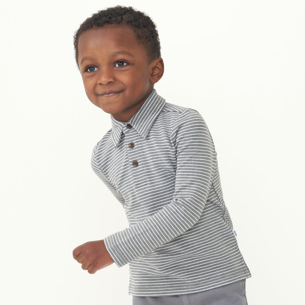 Child posing wearing a Heather Charcoal stripes polo shirt