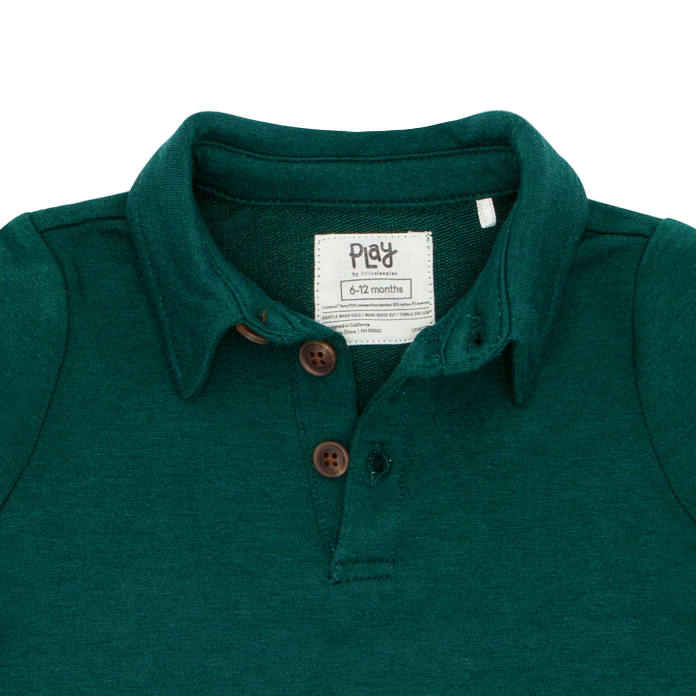 Close up detail image of the buttons on an Emerald polo shirt