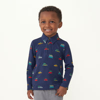 Child with a hand in his pocket wearing a Tree Traffic polo shirt