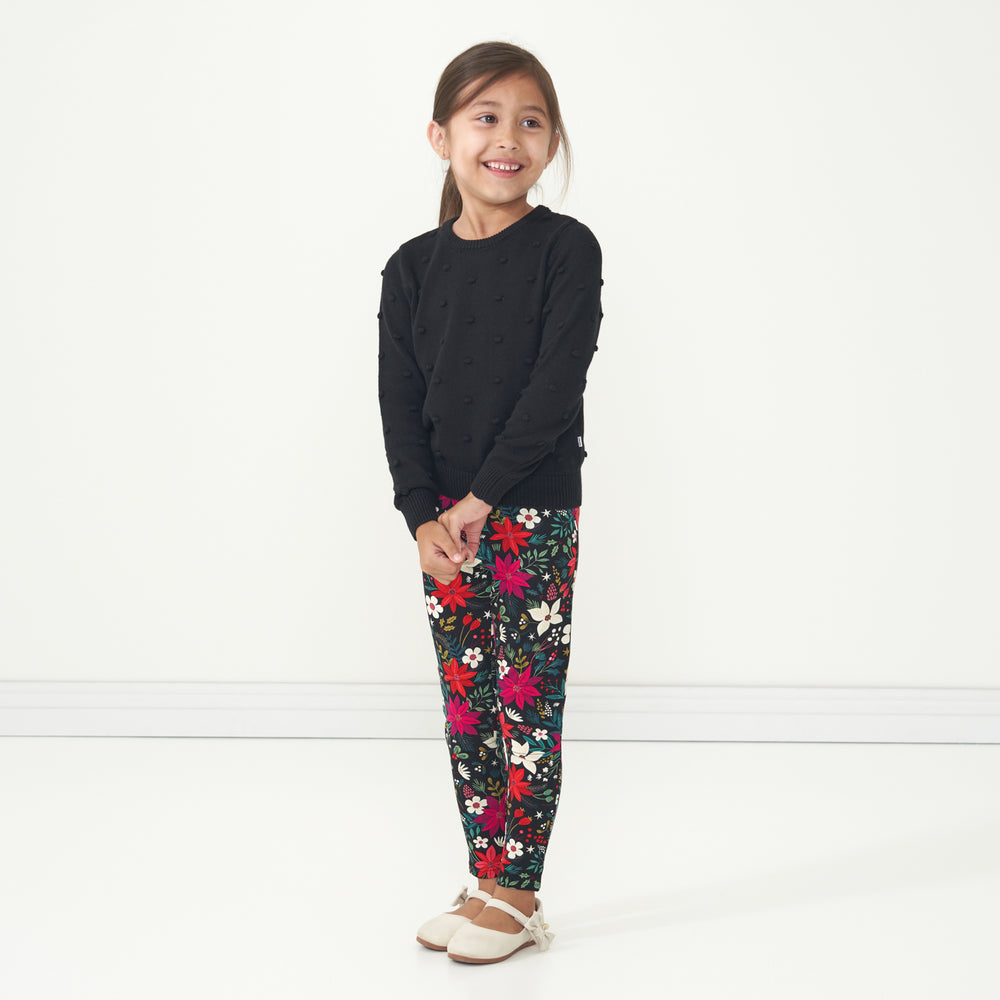 Child looking to the side wearing a Black pom pom sweater and coordinating Berry Merry leggings