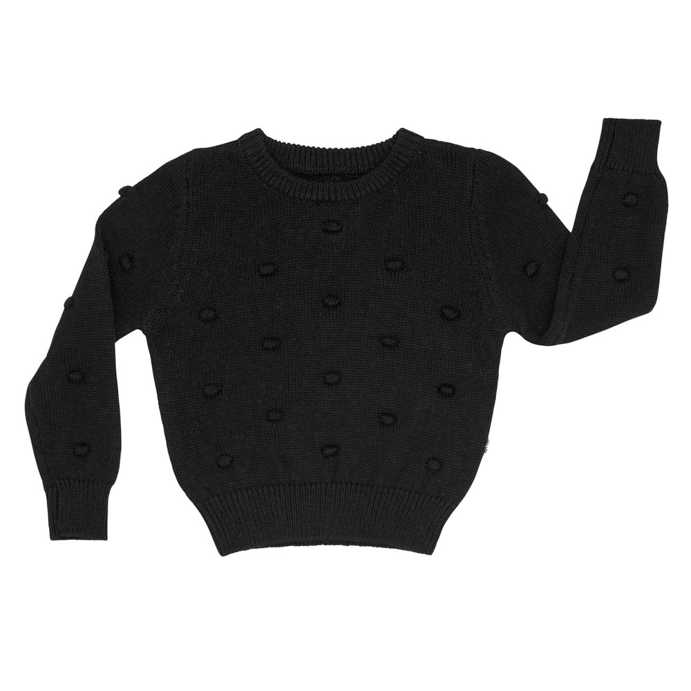 Flat lay image of a Black pom pom sweater