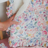 The Tiny Blooms Ruffle Mini Cloud Blanket folded over a crib