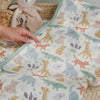 The Sweet Safari Mini Cloud Blanket folded in a baby crib