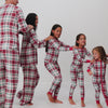 Family of five wearing matching Holly Plaid pajamas