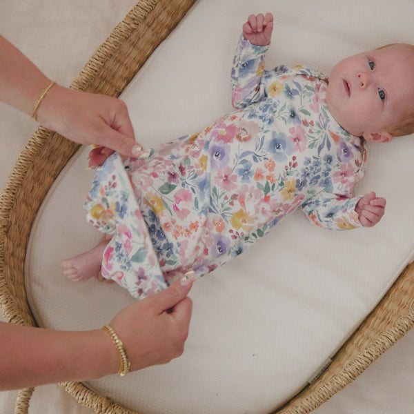 Adult demonstrating the envelope sweep on the Tiny Blooms Infant Gown