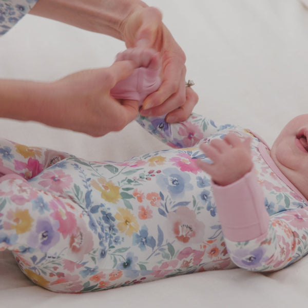 Parent folding over the mitten cuffs on a Tiny Blooms Lap Shoulder Zippy