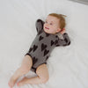 video of an infant lying on a white blanket wearing a heather hearts bodysuit