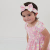 Video of a child wearing a Rosy Meadow luxe bow headband and matching dress
