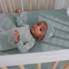 Newborn laying in a crib with the Willow Mini Crib Sheet