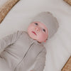 Baby wearing the Dove Gray Ribbed Infant Beanie with a matching zipper pajama 