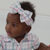 Video of a child wearing a Playful Plaid luxe bow headband and matching dress