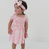 Video of a child wearing a Rosy Meadow puff sleeve smocked dress with bloomer and matching luxe bow headband