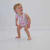 Standing toddler wearing the Pink Sweet Scoops Bubble Romper