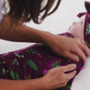 Adult adjusting the Cranberry Tree Traffic Swaddle & Luxe Bow Headband Set 