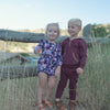 Video of boy and girl outdoors playing. Girl is wearing the Violet Meadow Bubble Romper