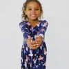 Smiling girl playing and dancing in the Twilight Ballet Bow Back Skater Dress