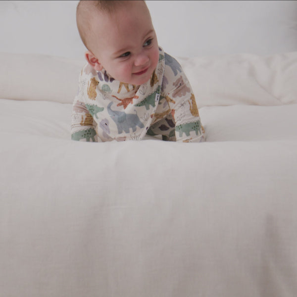 Baby wearing the Sweet Safari Bandana Bib with a matching newborn zipper pajama