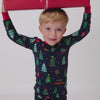 Child wearing the Navy Tree Traffic Two-Piece Pajama Set holding a wrapped present