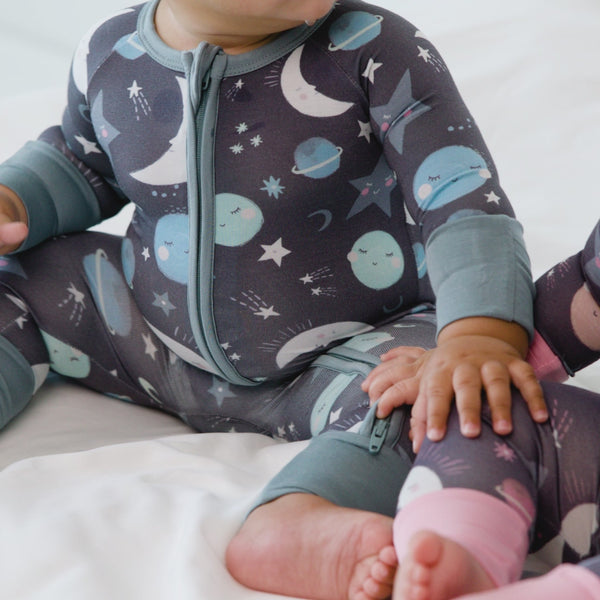 video of two children wearing coordinating Blue and Pink to the Moon and Back zippies on a bed