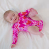 video of an infant lying on a white blanket wearing a pink hearts & crafts puff sleeve bodysuit